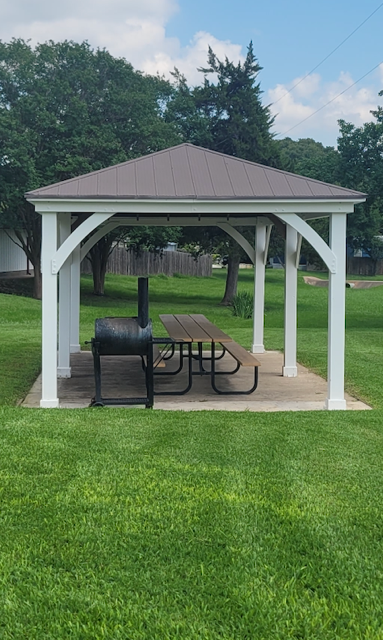 Covered pavilion with picnic table and smoker grill on the lawn